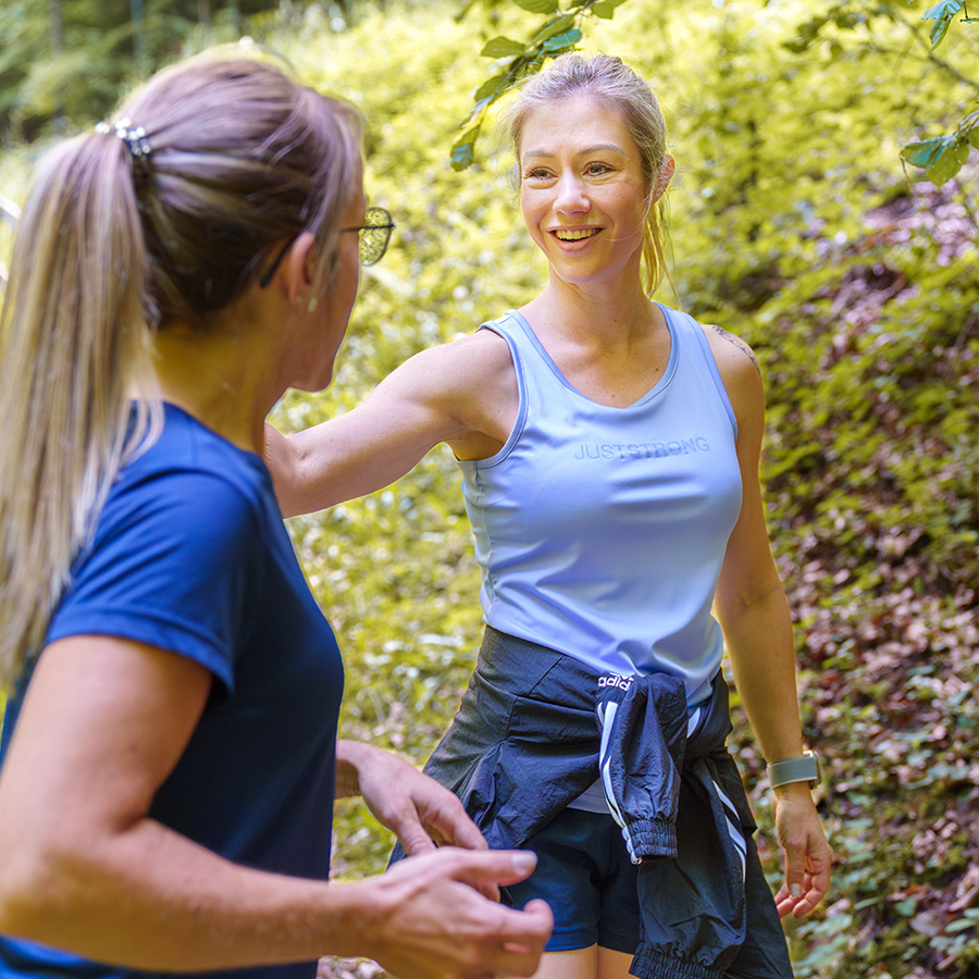 Szene eines Spaziergangs im Wald, der zeigt, wie leichte Bewegung und frische Luft helfen können, Stress abzubauen und Heisshunger vorzubeugen – ein zentraler Tipp aus dem Coaching von Jacqueline Moser in Thun.