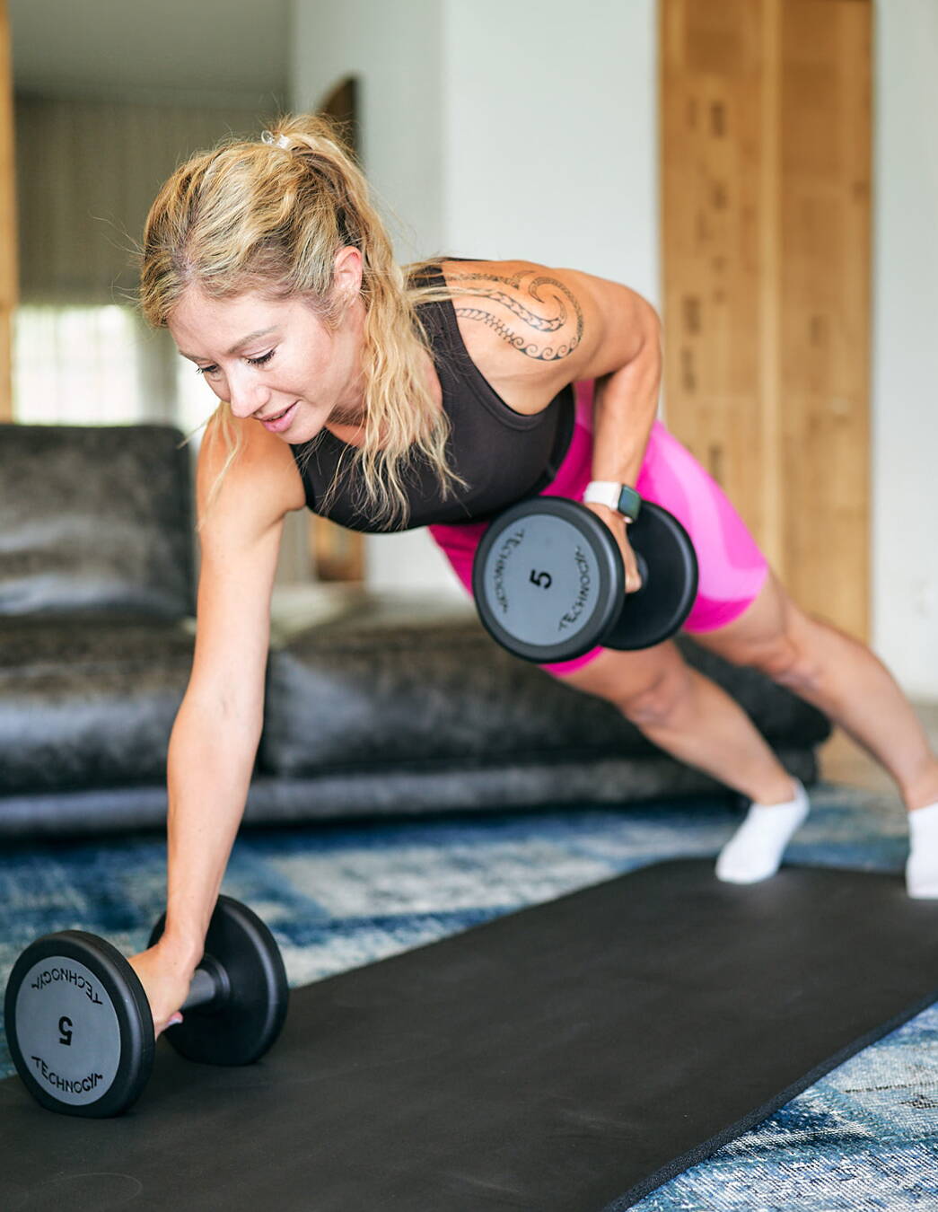 Gruppentraining mit Kurzhanteln – Small Circle Personal Training Region Thun Jacqueline Moser trainiert mit Kurzhanteln auf der Matte zu Hause – intensives Krafttraining im Rahmen der Gruppenkurse «Small Circle» in den Regionen Thun, Bern und Berner Oberland